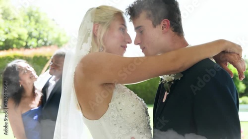 groom lifting bride with wedding veil, couple embracing for kiss, cloud wash rising over couple