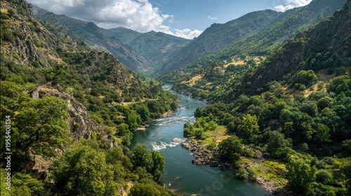 Scenic River Valley Surrounded by Lush Green Mountains and Dramatic Cloudy Sky in Nature, Capturing the Beauty and Serenity of Wilderness Landscapes