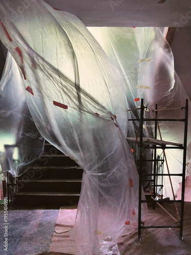 Renovation staircase covered with plastic sheets. High quality photo