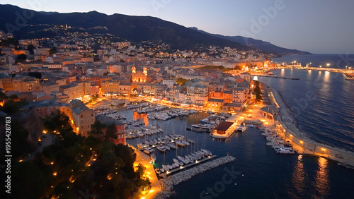 picturesque harbor during twilight hours, historic fortress overlooks tranquil water at evening. Bastia. France
