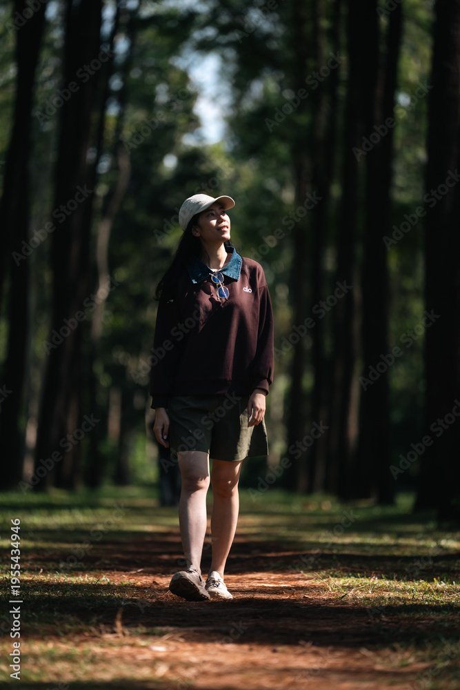 Obraz premium Asian woman relaxing in forest nature wellness mindfulness peaceful outdoor lifestyle mental health wellbeing natural therapy environment calm happiness sitting among trees