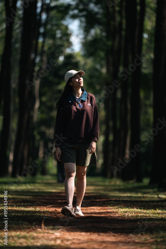 Asian woman relaxing in forest nature wellness mindfulness peaceful outdoor lifestyle mental health wellbeing natural therapy environment calm happiness sitting among trees