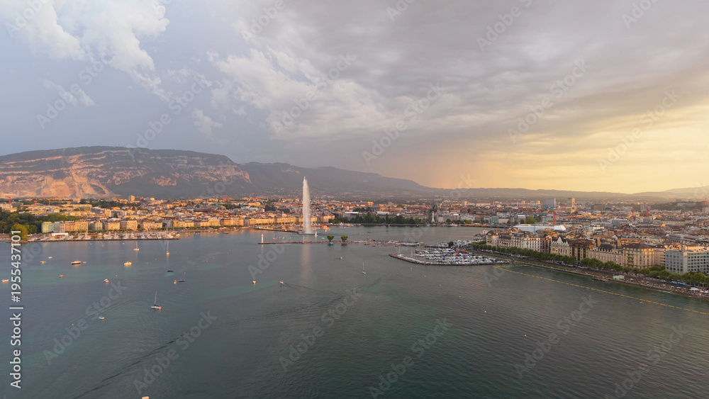 Fototapeta premium Golden evening over Geneva. Calm twilight at Geneva with reflections and mountain silhouette