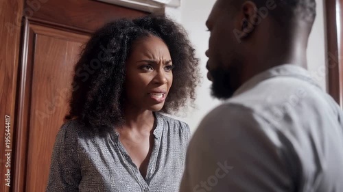 Young woman confronting her partner about infidelity in an apartment doorway showcasing raw emotions and the intensity of betrayal in a tumultuous relationship moment.