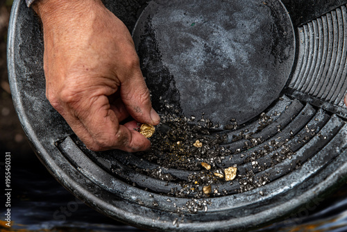 Foto Elderly man's hands holding gold sand, small pieces of gold nuggets