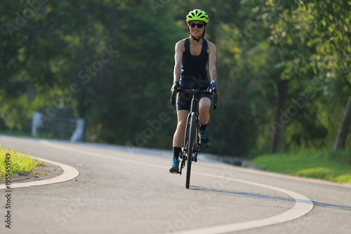Asian woman cycling in the summer park