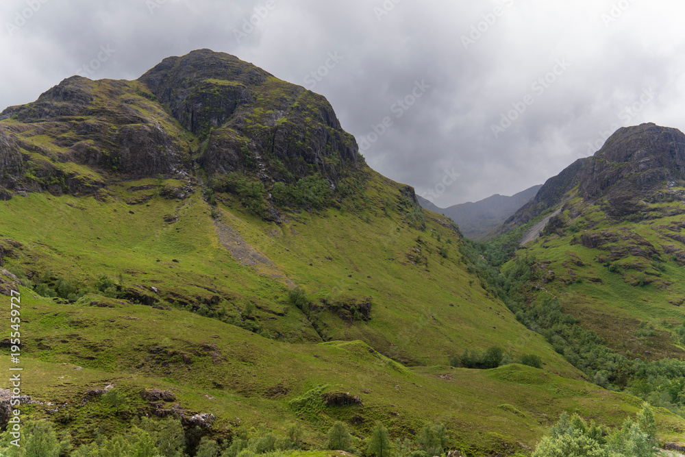 Fototapeta premium The Scottish Highlands offer spectacular landscapes of green mountains, deep valleys, and crystal-clear lochs . The distinctive hills covered in grass and heather, particularly those of Glencoe
