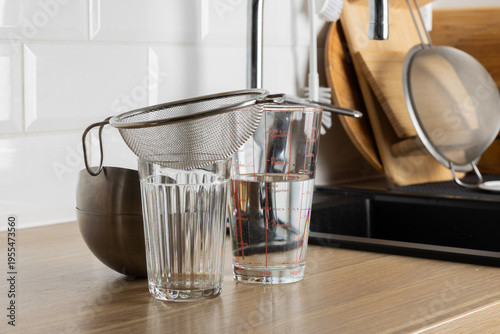 Foto A clear kitchen scene with a strainer and glasses on a countertop
