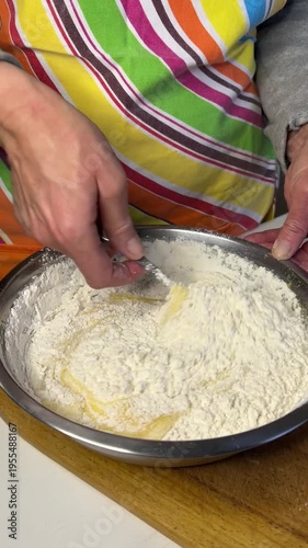 Vertical side view video of combining mixture with flour and mixing dough for honey cake preparation