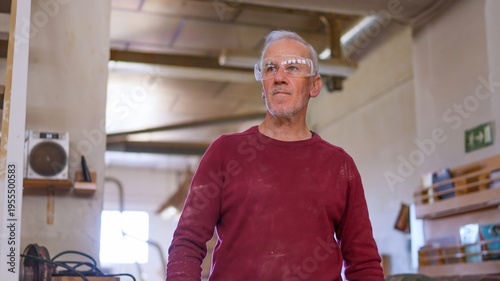 Senior carpenter wearing safety goggles working in workshop