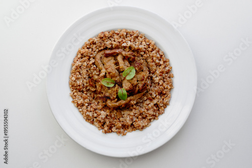 A hearty beef stew served atop toasted buckwheat groats, finished with a bright basil garnish. This wholesome, rustic dish makes a comforting, nourishing meal for lunch or dinner
