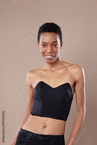 Beautiful confident Black woman with short natural hair posing in studio on beige background
