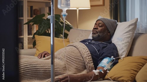 Gentle Scene Of Recovery At Home. Comfortable Setting Showing Man During Medical Infusion. Relaxed Male Patient In Cozy Room Receiving Intravenous Therapy With Peaceful Surroundings