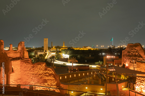 Diriyah at-turaif complex showing mud-brick architecture and palm trees glowing under night lights, Saudi Arabia