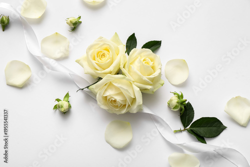 Beautiful white rose flowers and petals on grey background