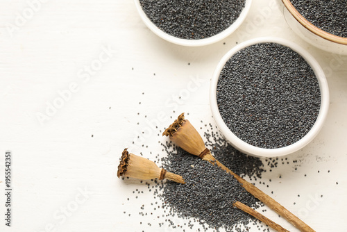 Photos Bowl with poppy seeds on white wooden background, closeup