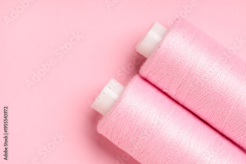 Spools of thread on pink ba...