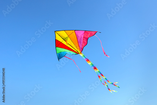 Colorful kite flying on blu...