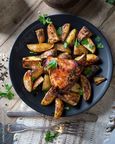 Country-style oven-baked chicken and potatoes on a wooden table