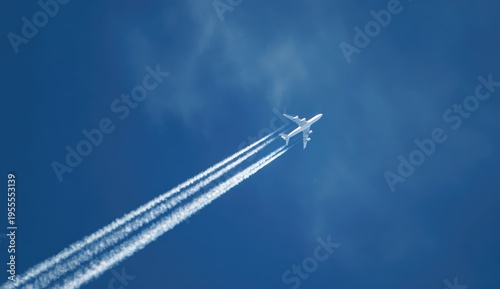 Airplane soaring through the clear blue sky leaving contrails.