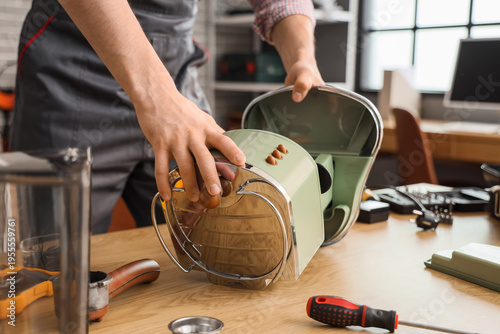 Φωτογραφία Male worker repairing coffee machine at table in workshop, closeup