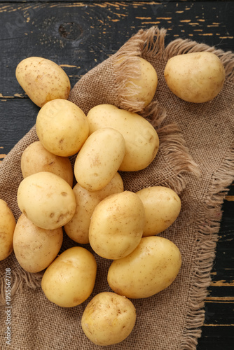 Many raw potatoes on black ...