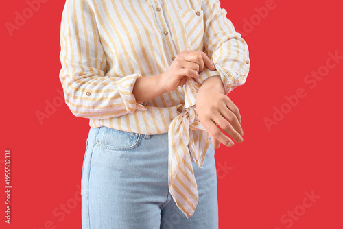 Canvas-taulu Mature woman rolling up her sleeve on red background