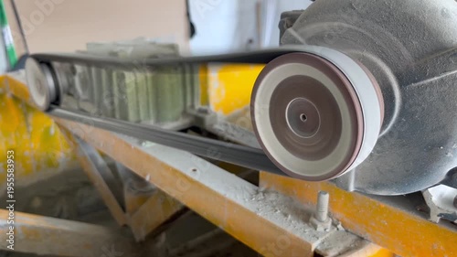 industrial belt and pulley system in motion on a construction machine, showing mechanical rotation and power transmission of heavy equipment for building and engineering projects