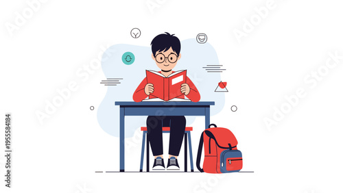 Focused young boy wearing glasses and sitting at a desk while reading a red book with his school backpack on the floor next to him in class.