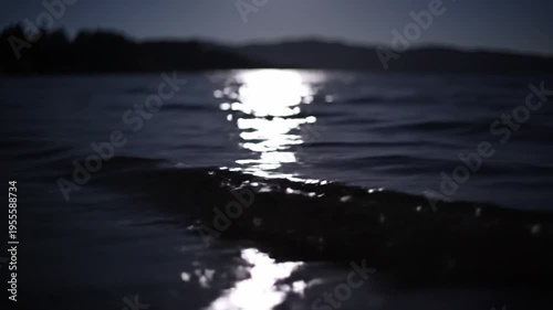 Moonlight water night reflection wave dark tranquil serene landscape outdoor scene with calm lake, gentle waves, peaceful nature, and shimmering moonlit sky evoking relaxation and quiet wilderness