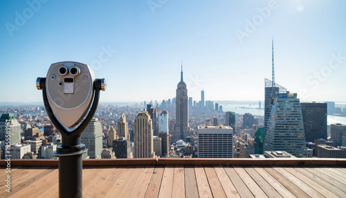 Observation deck with public binocular stand overlooking city skyline and clear sky  