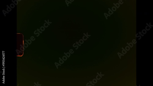 A dark abstract film background with visible scratches, dust, and organic film damage on analog super 8 film