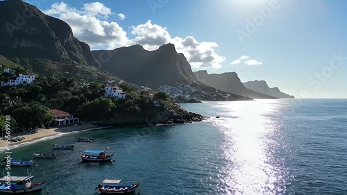 Scenic coastal village nestled against majestic mountains with boats moored in a tranquil bay under