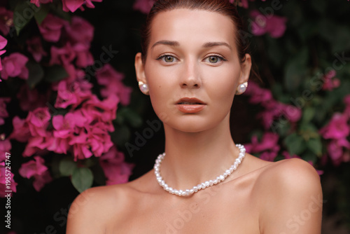 Sensual Beauty Portrait With Pearl Jewelry and Vibrant Pink Flowers