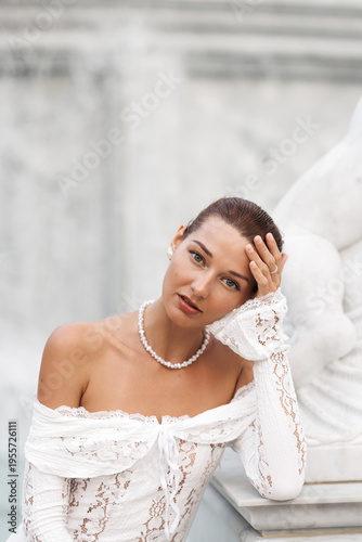Pensive Woman In White Lace Dress With Pearls By Marble Fountain