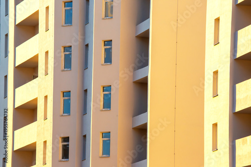 Building with windows in a city during sunset, casting shadows and light