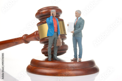 Miniature figurines depict a legal scene with gavel and two people in discussion about a case in a simple setting