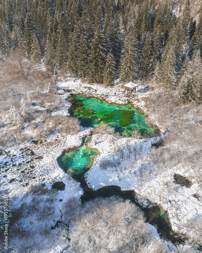 Emerald green water of river spring in the snowy winter