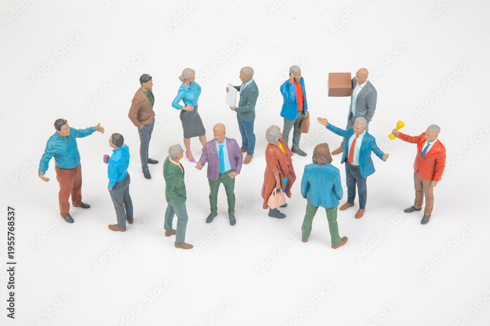 Fototapeta premium Miniature people in a group talking and interacting in a social setting during the day at a neutral background