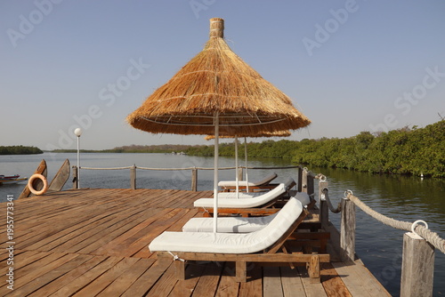 Toubakouta, Senegal. 22-02-2026. Sunbathing beach beds on a jetty in the Saloum delta. 