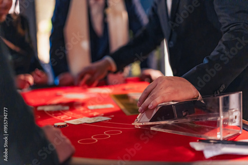 Cuadro en lienzo Casino dealer dealing cards on blackjack table with players around