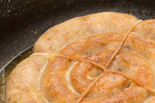 sausage is fried in a frying pan