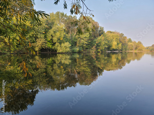 Vibrant Autumn Foliage Perfectly Reflected in Calm Still Lake Water on Clear Morning