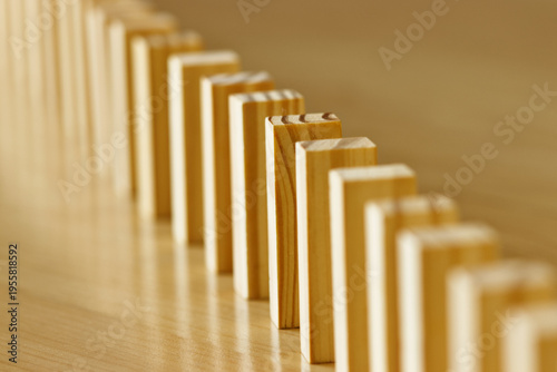 Wooden blocks arranged in a row on a wooden surface with warm lighting and shallow depth of field