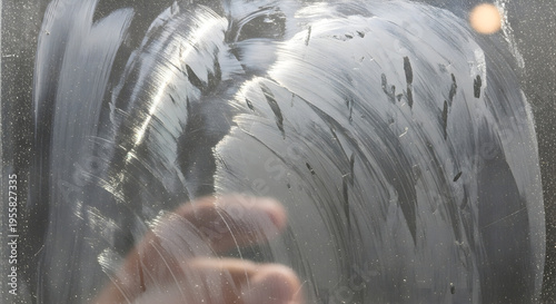 Smudged fingerprints and streaks on a dirty glass surface with backlighting