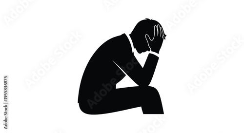A person sits in despair head in hands a stark silhouette