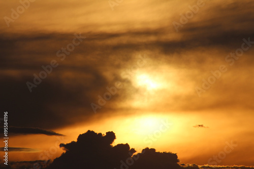 Dramatic sunset sky with fluffy clouds at dusk. Beautiful golden hour landscape background. Colorful orange and purple clouds during sunset. Final of the day sunset with clouds.