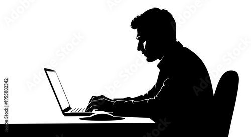 Silhouette of a man working on a laptop at a desk in a dimly lit room, focused on screen