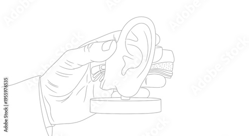 Hand holding ear-shaped stamp with ink pad, concept of listening, approval, or censorship