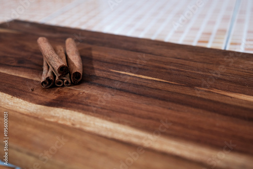 Εκτύπωση καμβά Cinnamon sticks rest on rich, warm-toned wooden surface